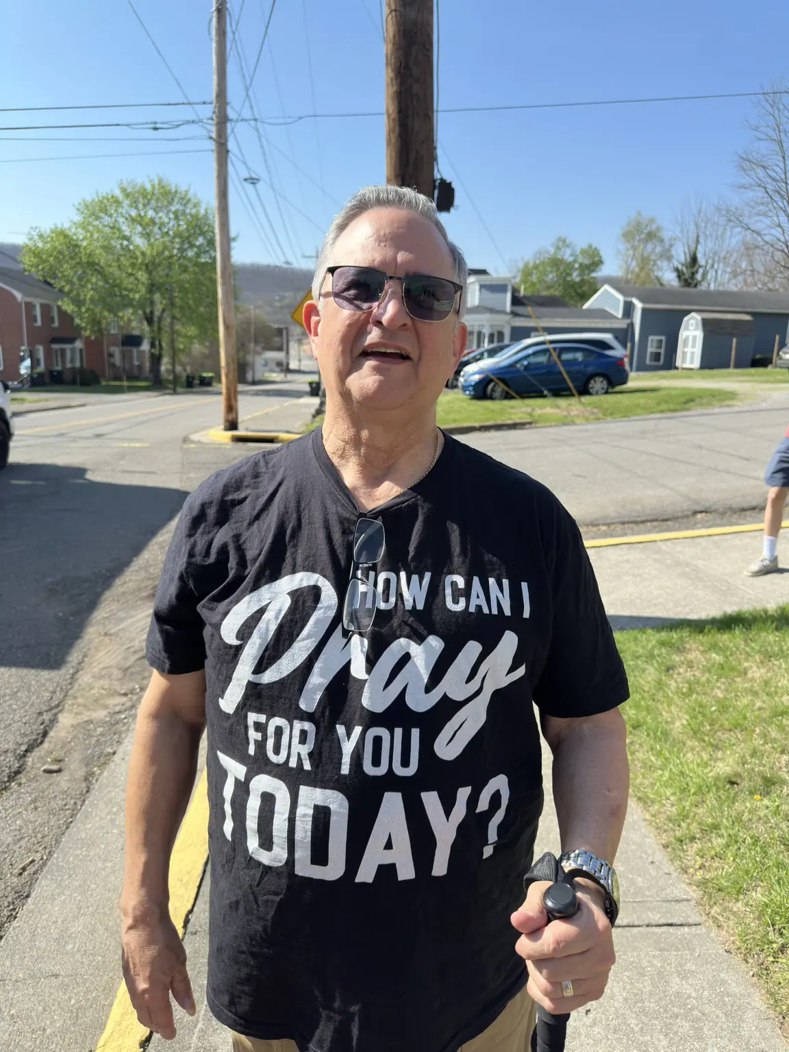 Senior Pastor Dr. Henry Fiske wearing a shirt that asks, How can I pray for you today?